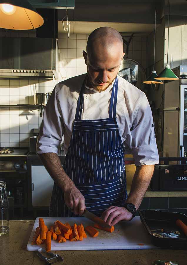 Chef préparant à manger pour Curty's traiteur tendance